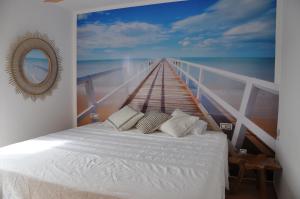 a bed in a room with a painting of a pier at Exclusive Stars view Experience in La Oliva