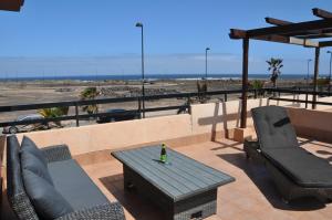 a patio with a table and chairs and the beach at Exclusive Stars view Experience in La Oliva