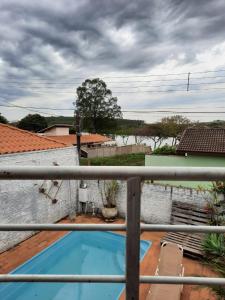 uma vista para uma piscina a partir de uma varanda em CASA DE CAMPO PATRIMÔNIO em Brotas