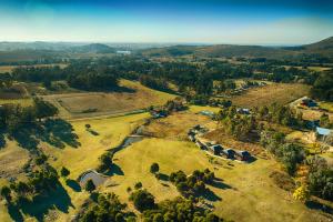 an aerial view of a field with trees and a river at Cabañas Valle de los Ciervos in Tandil +153 photos