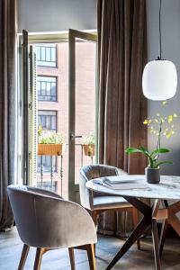 a dining room with a table and two chairs at Radisson Blu Hotel, Madrid Prado in Madrid