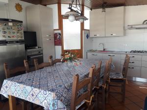 una cocina con mesa y sillas y una cocina con mesa en Casa NUPI, en SantʼAlessio Siculo