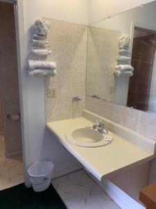 ein Badezimmer mit einem Waschbecken, einem Spiegel und Handtüchern in der Unterkunft Boone trail inn in Middlesboro