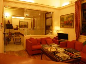 a living room with a red couch and a table at Art Gallery Hotel in Athens