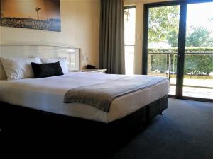 a bedroom with a large bed and a large window at Kobbers Motor Inn in Dalby