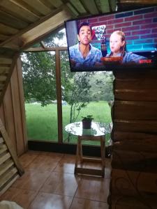 een flatscreen-tv in een kamer met een tafel bij Nature house in Monteverde Costa Rica