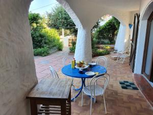 una mesa azul y sillas en un patio en Villa Manuela sul mare, en S'Archittu