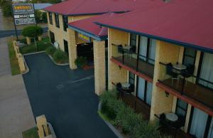 a red brick building with a red roof at Kobbers Motor Inn in Dalby