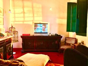 ein Wohnzimmer mit einem TV auf der Kommode in der Unterkunft Casa Colonial em Praia Paradisíaca in Barra de São João