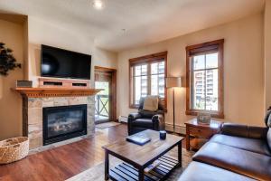 a living room with a fireplace and a tv at Main Street Station II in Breckenridge