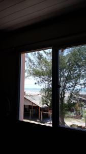 ein Fenster mit Blick auf den Strand von einem Haus aus in der Unterkunft Beira mar Mariluz in Imbé