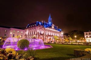 a building with a fountain in front of it at night at ty-yan in Tours