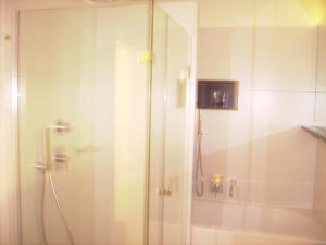 a shower with a glass door in a bathroom at Appartements Christa in Dobbiaco