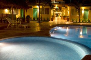 a large swimming pool in a resort at night at Bungalows Las Arenas in San Patricio Melaque