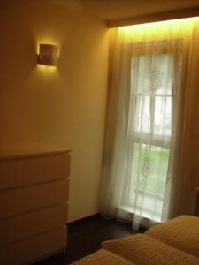 sypialnia z łóżkiem i oknem z zasłonami w obiekcie Appartements Christa w mieście Dobbiaco