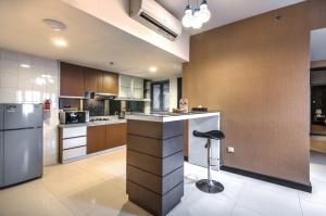 una gran cocina con encimera y taburete en Verwood Hotel and Serviced Residence, en Surabaya