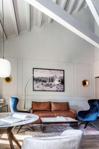 a living room with a brown couch and blue chairs at Radisson Blu Hotel, Madrid Prado in Madrid