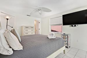a bedroom with a large bed and a flat screen tv at Anna Maria's Finest in Anna Maria