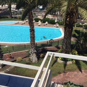 een uitzicht over een zwembad met palmbomen bij Suite Monte Golf à Playa del Cura, Grande Canarie, le Soleil toute l’année, ici c’est possible ! in Playa del Cura