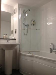 a bathroom with a shower and a sink and a tub at Northallerton Motel in Northallerton