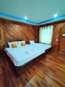 a large bed in a room with wooden floors at Palmsuay Resort in Ban Dong Klang