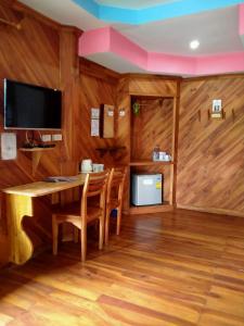 a dining room with wooden walls and a table and chairs at Palmsuay Resort in Ban Dong Klang