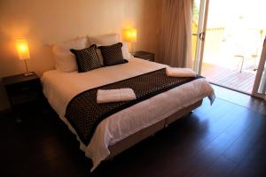 a bedroom with a large bed with two pillows on it at Siesta Villa in Jindabyne