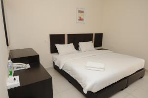 1 dormitorio con 1 cama grande y teléfono en ND Hotel Melaka, en Melaka