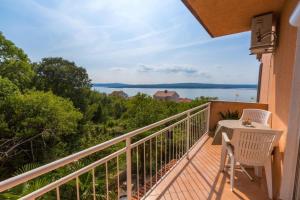 a balcony with a table and chairs and a view of the water at Two-Bedroom Apartment in Crikvenica XII in Dramalj