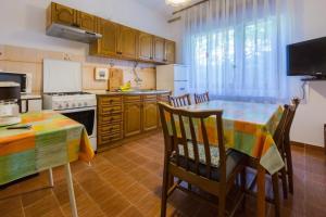 a kitchen with a table and chairs and a kitchen with a stove at Apartment in Dramalj 5751 in Dramalj