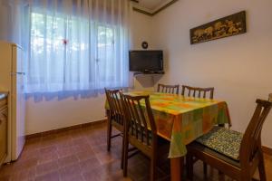 a dining room with a table and chairs and a television at Apartment in Dramalj 5751 in Dramalj