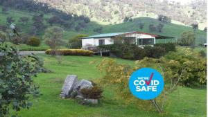 a sign in front of a house in a field at Elm Cottage in Tumut