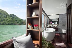 La salle de bains est pourvue d'une baignoire et offre une vue sur l'eau. dans l'établissement Orchid Classic Cruise, à Hạ Long