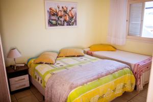 Duas camas num quarto com uma janela em Marili Apartamentos em Torres