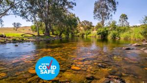 a river with a sign that says we were cold safe at Elm Cottage in Tumut