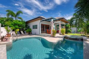 a swimming pool in front of a house at Orchid Paradise Homes Villa in Hua Hin