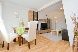 ein Wohnzimmer mit einem Tisch, Stühlen und einem TV in der Unterkunft Two-Bedroom Apartment in Gross Kordshagen I in Arbshagen