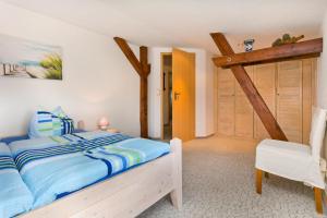 ein Schlafzimmer mit einem Bett und einem weißen Stuhl in der Unterkunft Two-Bedroom Apartment in Gross Kordshagen I in Arbshagen