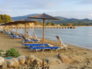 una fila de tumbonas y sombrillas en una playa en Kalokerino en Olympiada