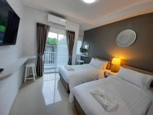 a hotel room with two beds and a balcony at The Viera Chiangrai in Chiang Rai