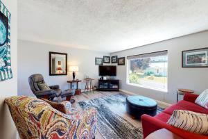 sala de estar con sofá rojo, sillas y ventana en Cascade River Watch, en Cascade Locks