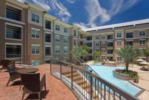 a balcony with a pool and a building at Gorgeous Furnished Apartments near Texas Medical Center & NRG Stadium in Houston