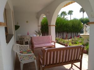 un patio con panchina, tavolo e sedie di Villa Montsià a Sant Carles de la Ràpita