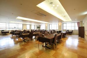 Blancart Misasa في Misasa: غرفة كبيرة بها طاولات وكراسي ونوافذ