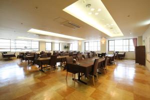 a large room with tables and chairs and windows at Blancart Misasa in Misasa