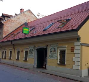 a building with a red roof on a street at Guesthouse Stari Tišler in Ljubljana