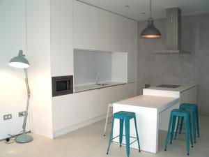 a kitchen with white cabinets and blue stools at El 16 Ruzafa in Valencia