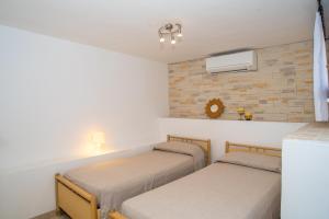 two beds in a room with a wall at Appartamento del Cormorano in Olbia