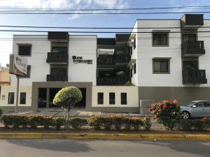 a white building with balconies on a street at Invernadero Inn in Veracruz