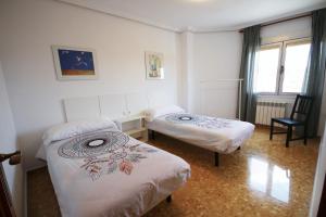 a room with two beds and a chair at 380 Delicia de Teruel in Teruel